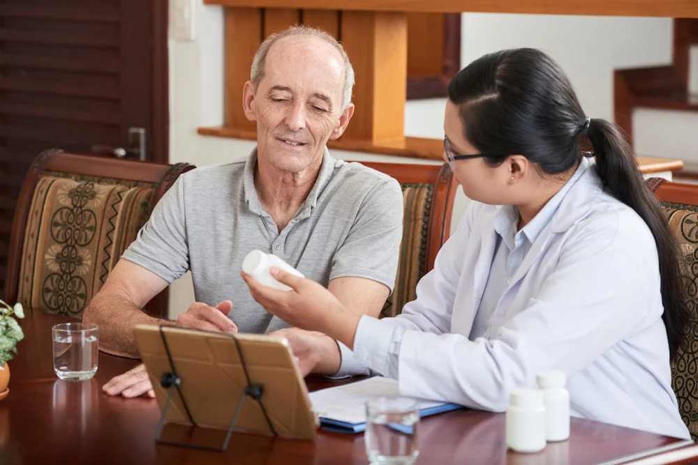 A physician reviews a medication with an older patient